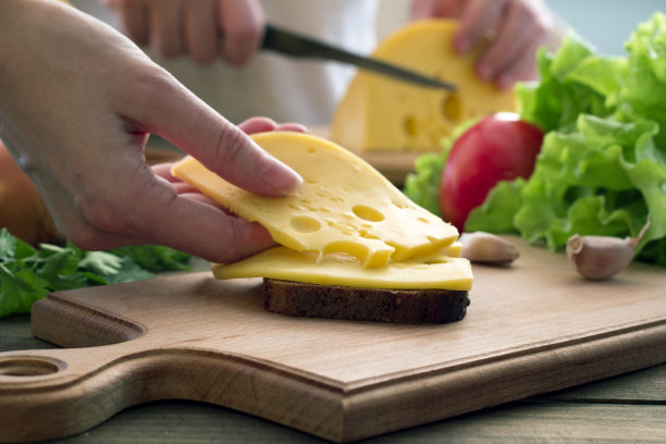 手在面包上放了一块奶酪图片下载
