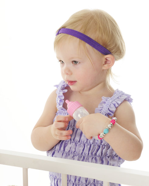 婴儿床旁边有一个婴儿奶瓶图片下载