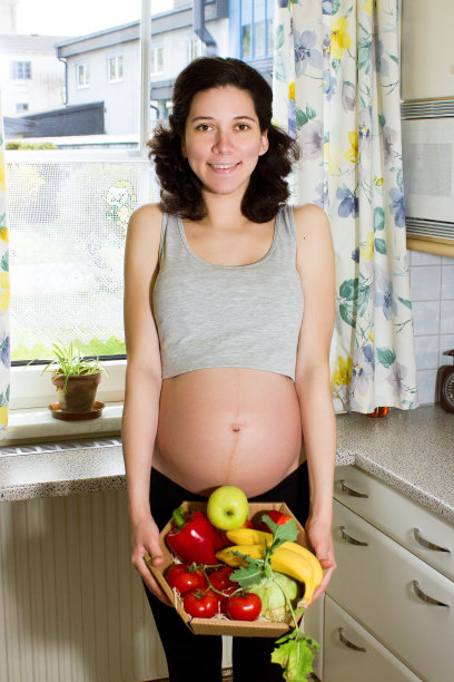 年轻漂亮的孕妇提着一篮子水果图片下载