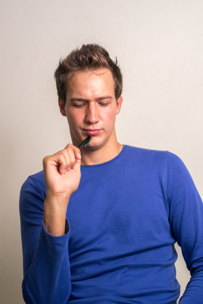 年轻的白人拿着笔在思考图片下载