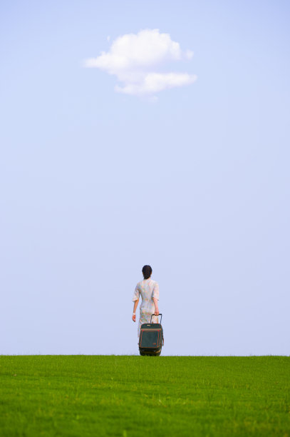 漂亮的年轻女子带着一个手提箱旅行图片下载