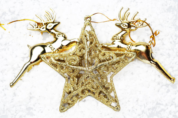 金色的星星和金色的驯鹿在雪地上装饰圣诞节图片下载