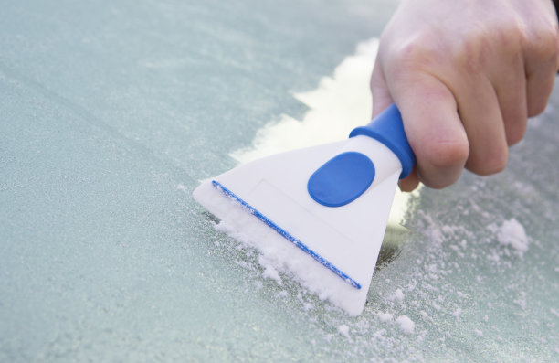 用刮刀从汽车挡风玻璃上刮取冰器图片下载