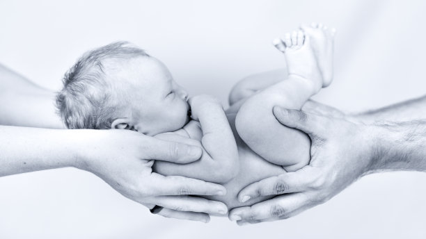 快乐的新生婴儿在父母手中图片下载