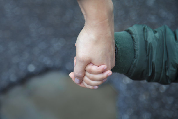 孩子和母亲手牵着手。图片下载