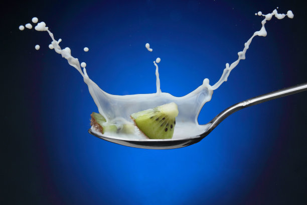 切片猕猴桃用勺子盛着牛奶图片下载