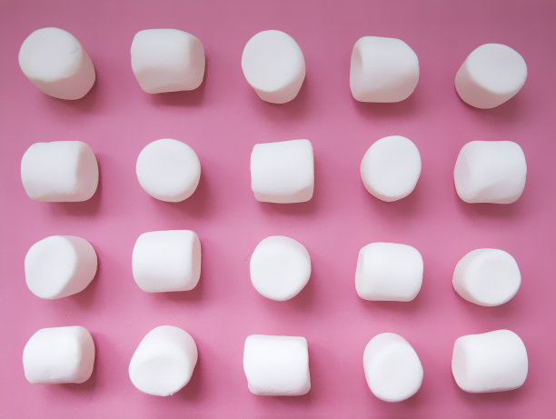 粉红色背景上的白色棉花糖素材图片