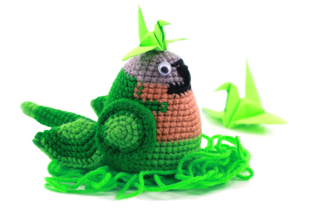 手工钩针鹦鹉娃娃在白色的背景图片下载
