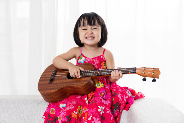 快乐的亚洲华人小女孩弹尤克里里图片下载