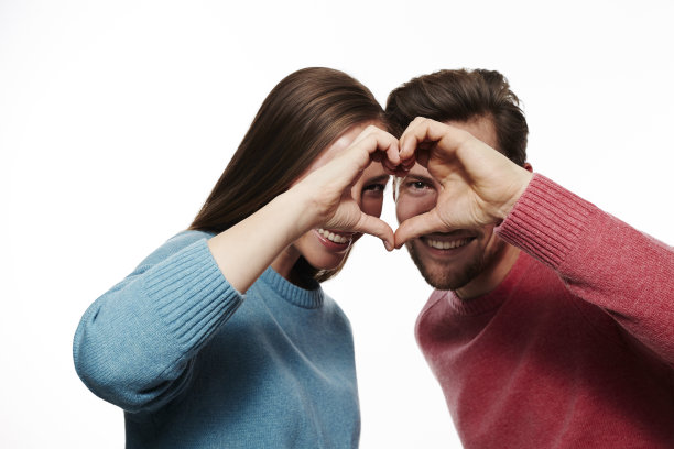 深情的情侣透过心形的手偷窥图片下载