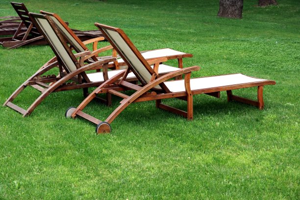 晚上在草坪上的空木制风化躺椅图片下载