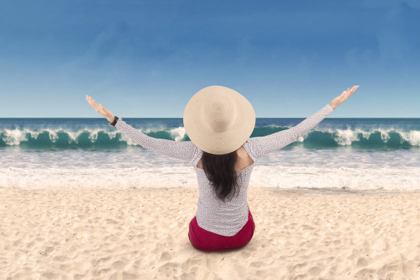 无忧无虑的女人坐在海滩上图片下载