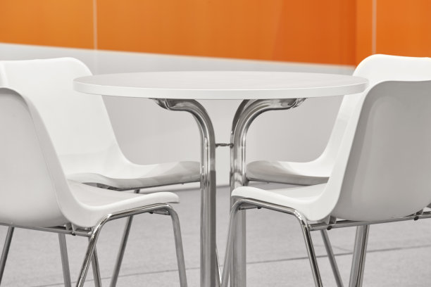 白色的塑料椅子和桌子。橙色的墙壁装饰图片下载