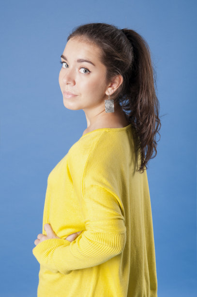 穿着黄色夹克的女孩半转身。图片下载