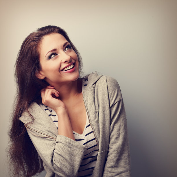 年轻随意的女人抬头笑着。特写镜头的肖像图片下载