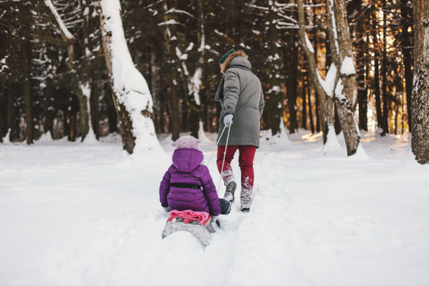 父亲和女儿在冬天的森林里放松图片下载