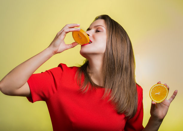 一个穿着红裙子拿着橘子的女人图片下载