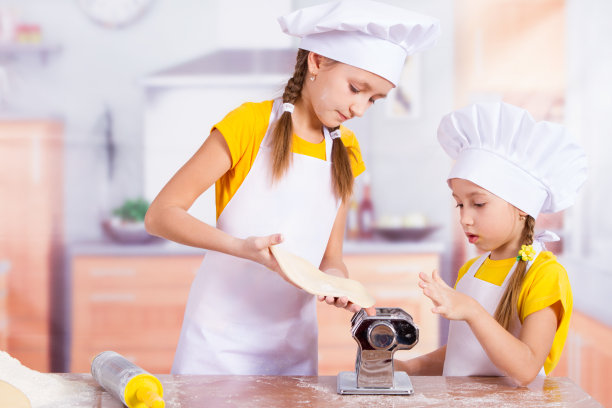 两个小厨师在拉伸面团图片下载