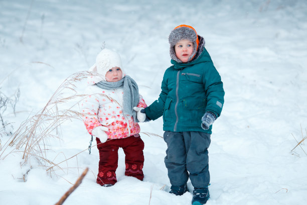 白雪背景下的小女孩和小男孩图片下载