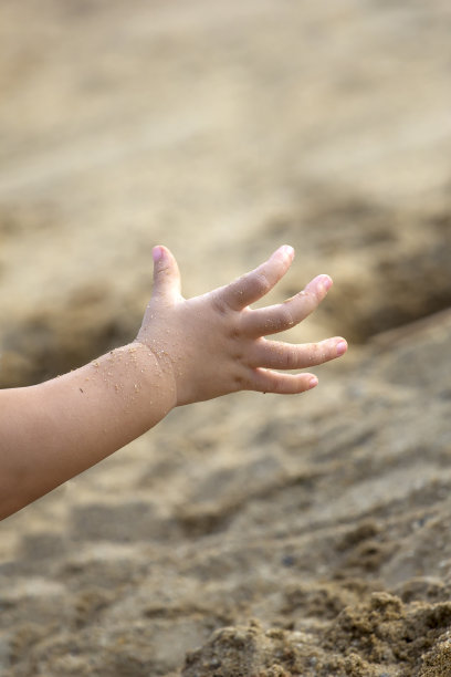 孩子们在玩沙子。孩子伸手去拿东西图片下载