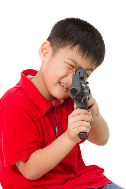 亚洲小男孩玩塑料玩具枪图片下载