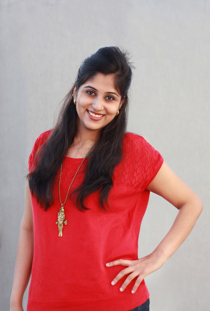 在灰色背景下，美丽的印度女人对着相机微笑图片下载