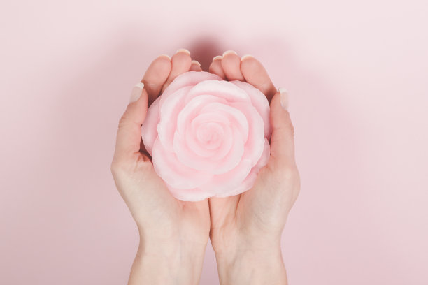 在孤立的粉红色背景上，粉红蜡在手中升起图片下载