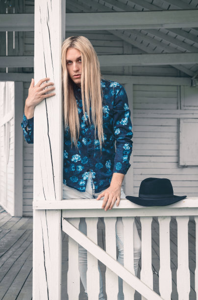 时尚拍摄。一个年轻人在白色门廊上摆姿势图片下载