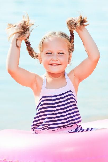 快乐的笑着的女孩挽着辫子。健美的形象图片下载