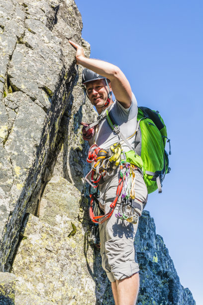 一个站在岩架上的登山者。图片下载