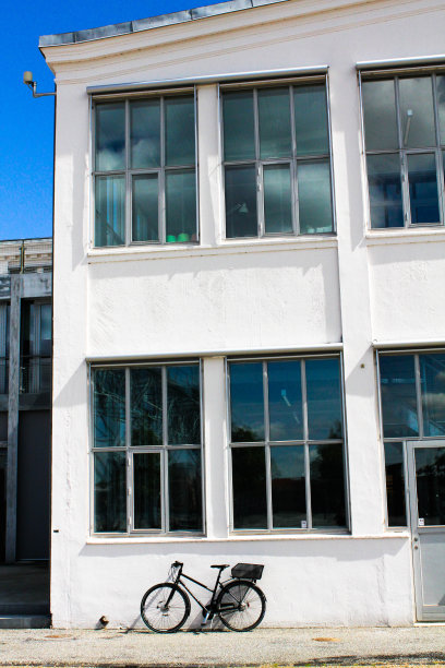 孤独的自行车在白色的阁楼建筑前图片下载