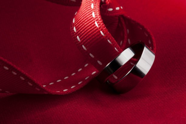 带有红色丝带和红色背景的结婚戒指图片下载