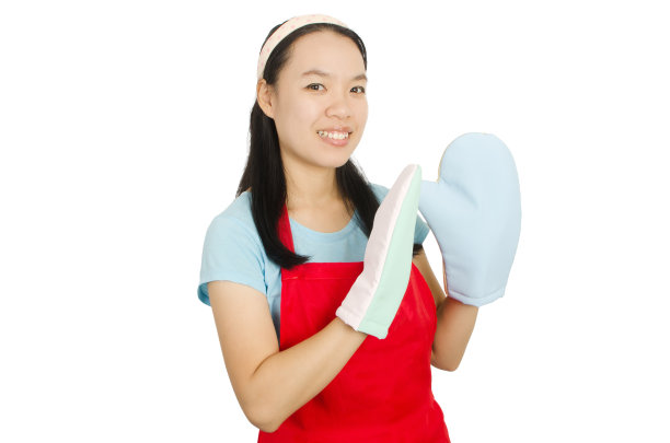 年轻的亚洲女人穿着红色围裙和烤箱手套图片下载