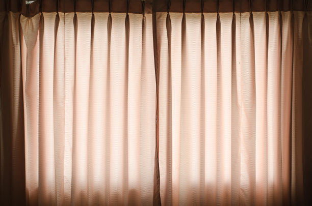 在黑暗的房间里，阳光照在窗帘上图片下载