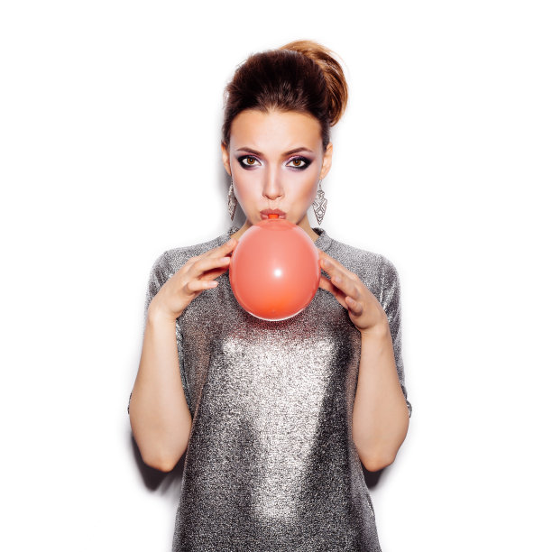 时尚美女吹红气球。漂亮女人肖像图片下载
