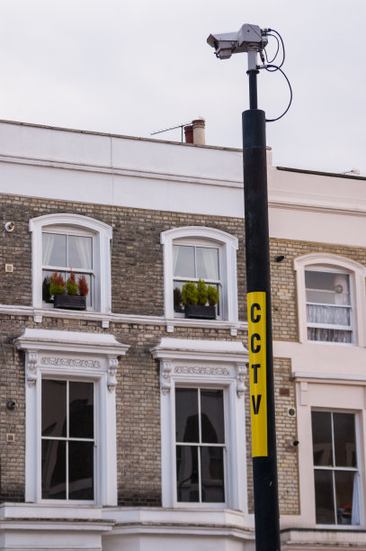 在传统的英国维多利亚式公寓的杆子上安装闭路电视摄像头图片下载