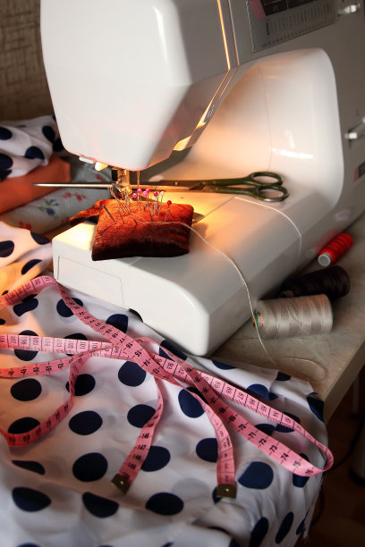 一块布料，大头针，剪刀和一台缝纫机。图片下载