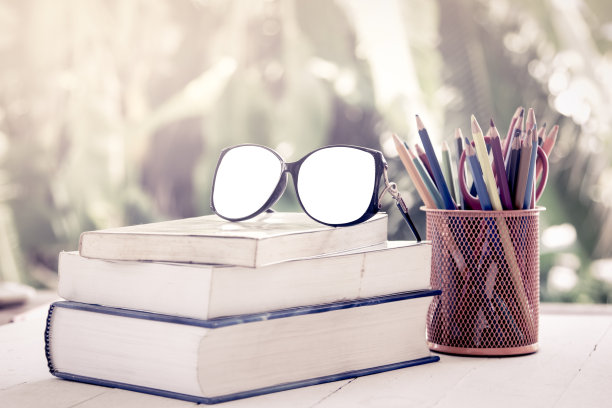 用蜡笔画在旧书堆上的眼镜图片下载