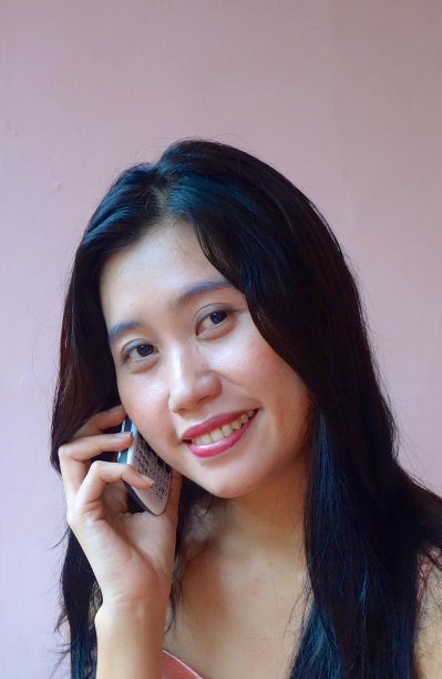 印度尼西亚妇女使用手机微笑图片下载