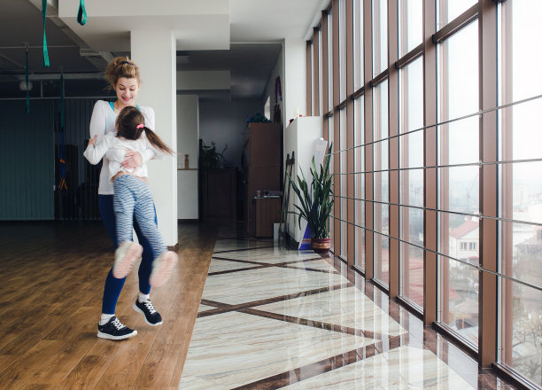 母亲在体育馆里使女儿扭动身体图片下载