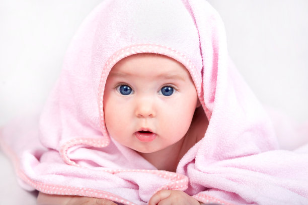 可爱的小女孩，在粉红色的毛巾下向外张望图片下载