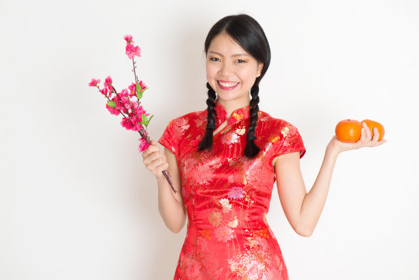 亚洲中国女孩拿着橘子和梅花图片下载