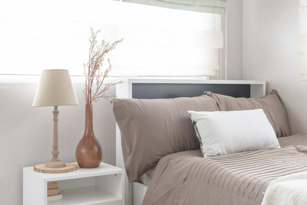 白色的桌子边放着一盏灯和一只花瓶图片下载