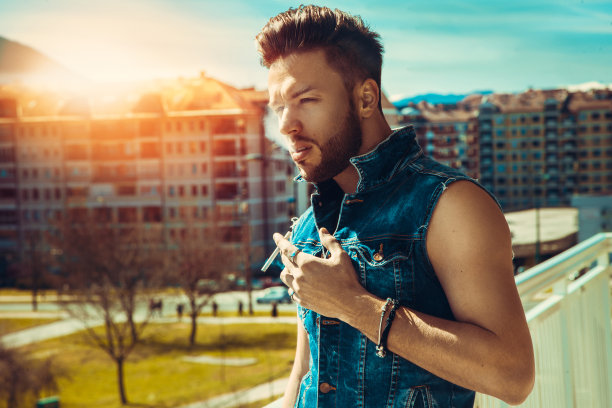 横向照片性感的男时装模特与香烟图片下载