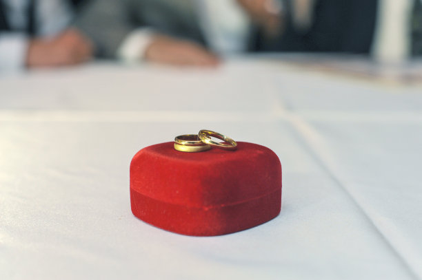 红色礼品盒上的结婚戒指图片下载