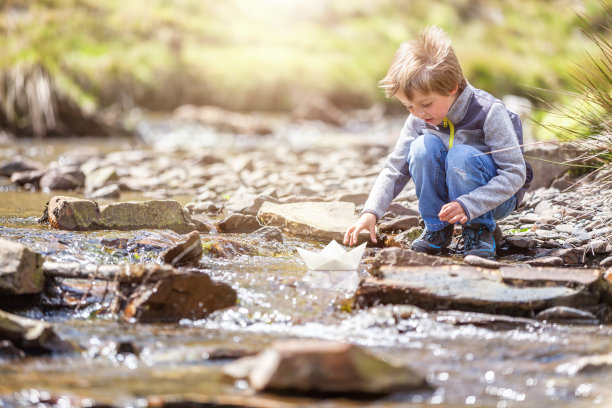 男孩驾着一只纸船图片下载