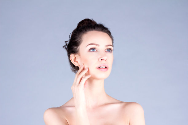 触摸脸颊的美女。结果面部。图片下载