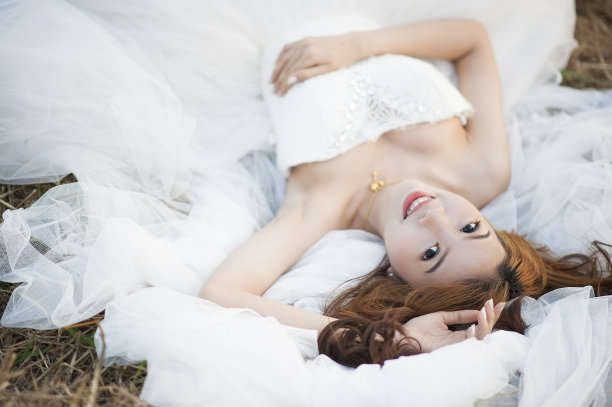 一个可爱的少女躺在草地上的肖像图片下载