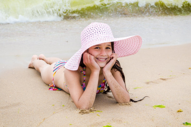 海滩上戴着帽子的女孩图片下载