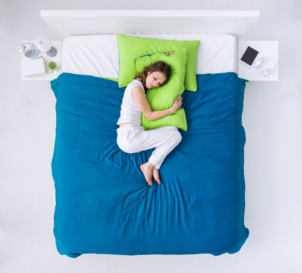 女人蜷缩在床上图片下载